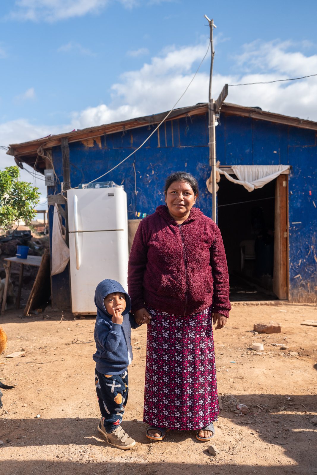 Beneficiarios de proyecto comunitario frente a su vivienda